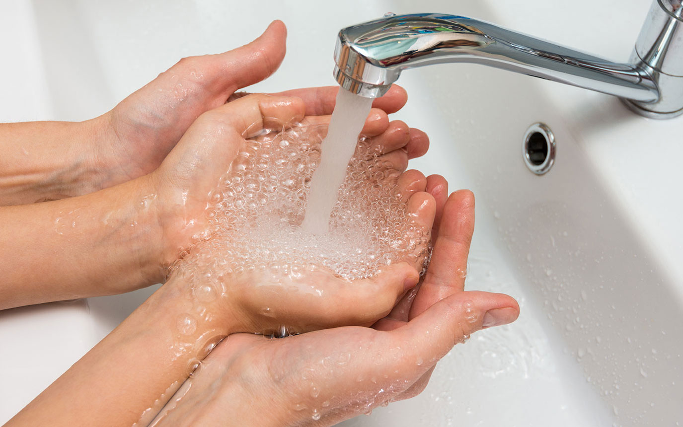 Hände unter Wasserhahn