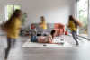 woman-trying-work-laptop-from-home-while-her-children-are-running-around-bn.jpg