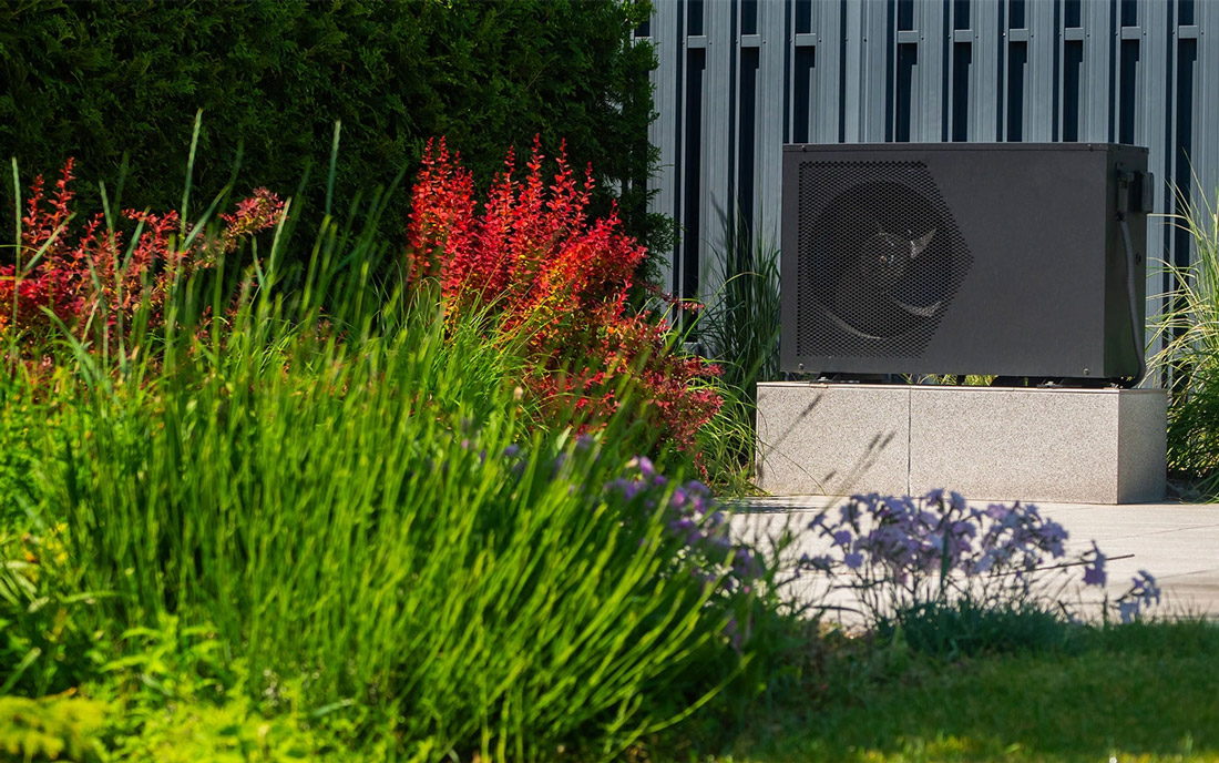 Wärmepumpe im grünen Garten