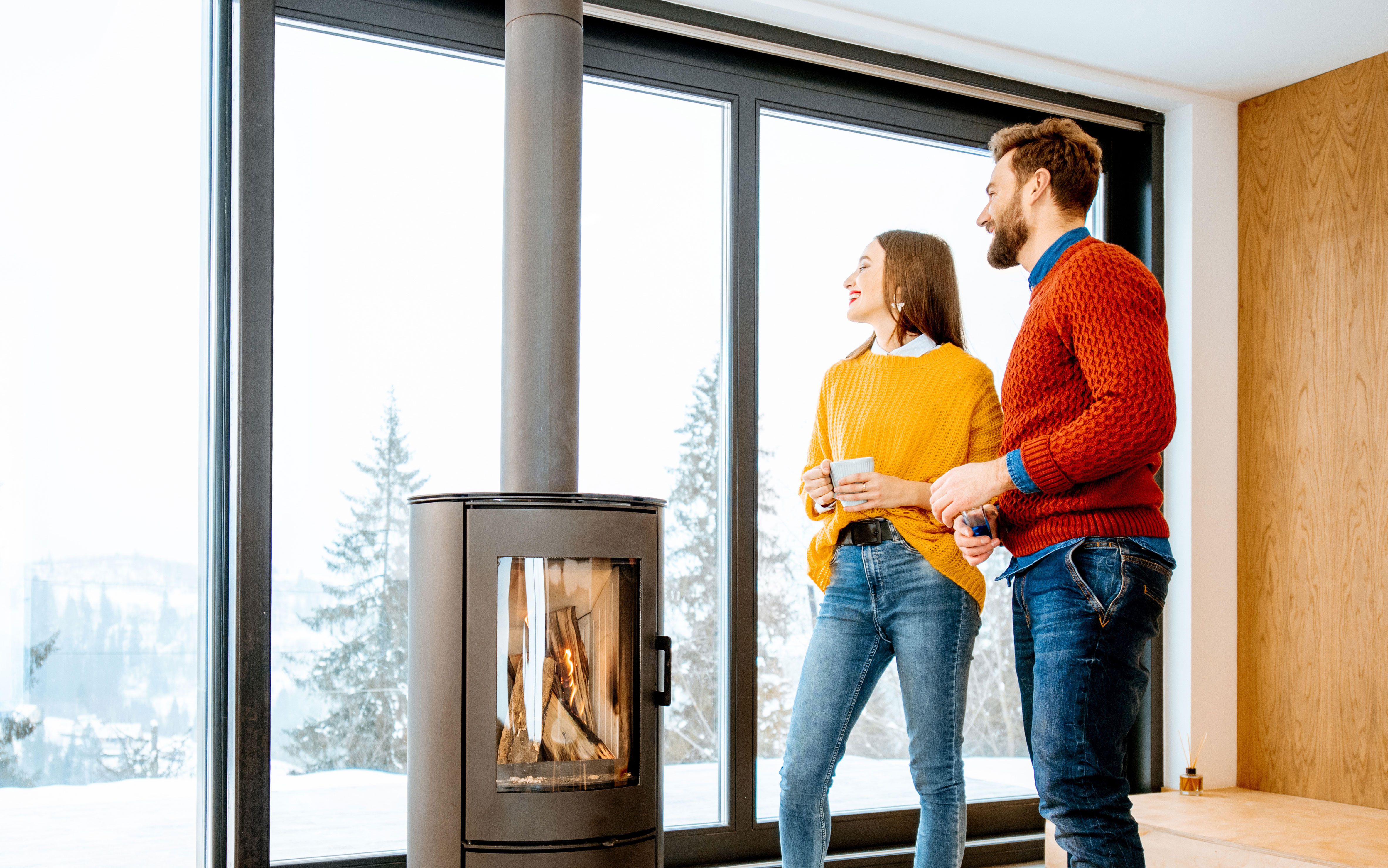 Pärchen vor einem Kaminofen mit einem langen Ofenrohr