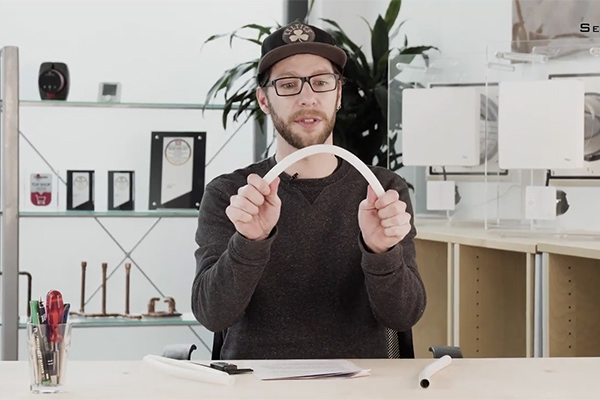 Mann zeigt Flexibilität von PE-RT-Rohr