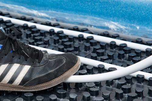 Fuß auf dem Rohr auf dem Noppensystem