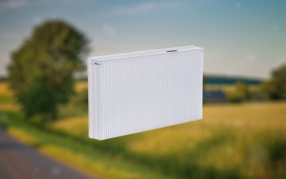 Symbolbild: Luftfilter vor Wiesenlandschaft – reinigt auch natürliche Landluft von Pollen und Partikeln für saubere Raumluft.