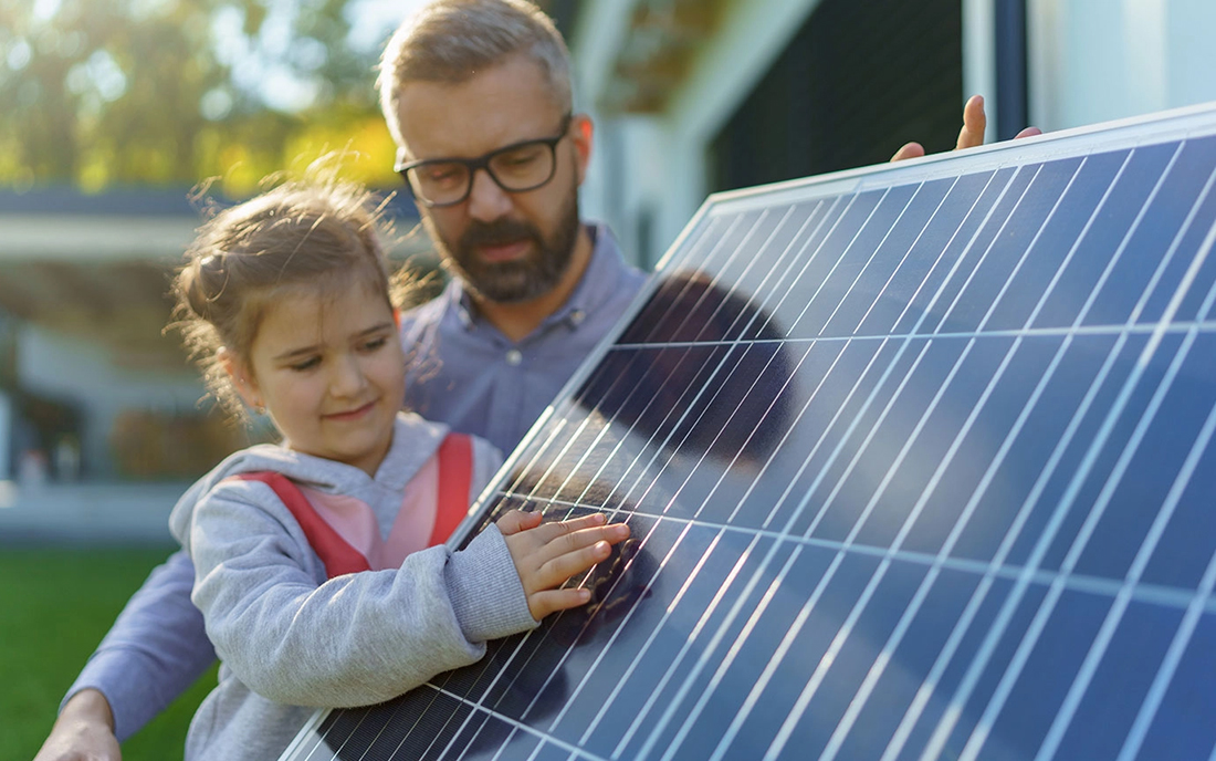 Vater und Kind neben PV-Modul