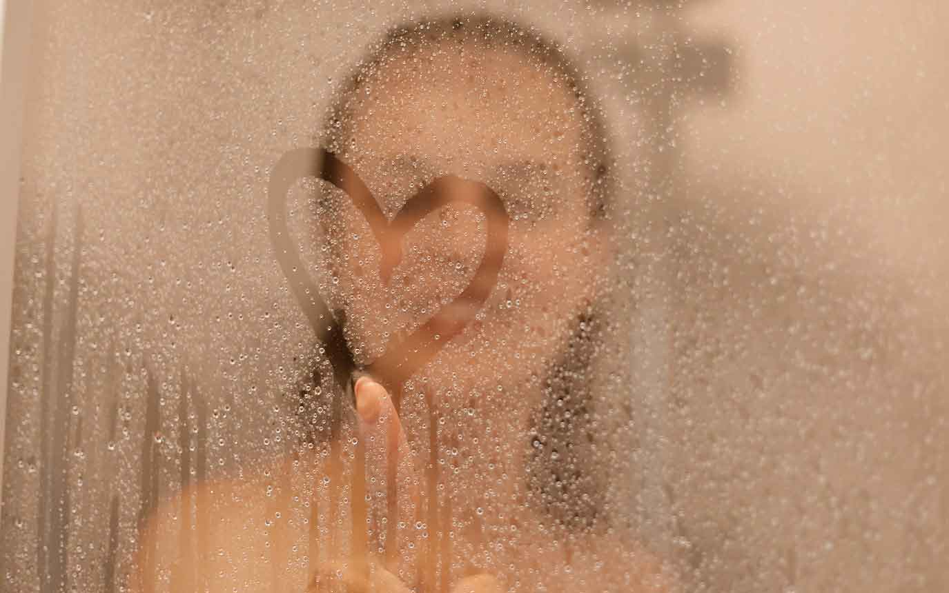 Frau in Dusche malt Herz