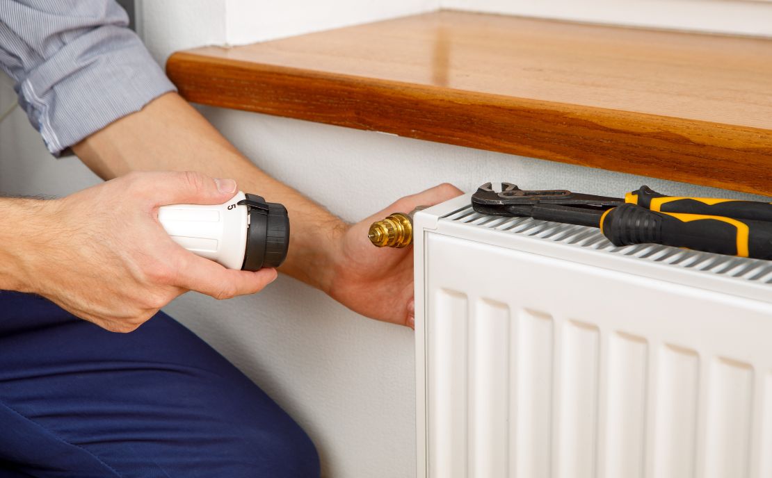 Mann bringt Thermostatkopf auf Thermostatventil an