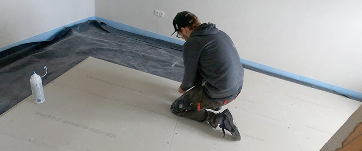 Mann verlegt Trockenestrichplatten