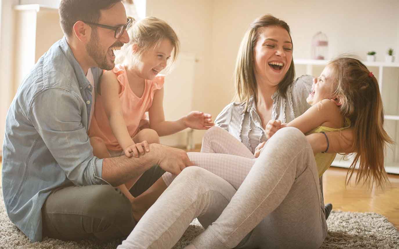 Familie tobt auf dem Fußboden