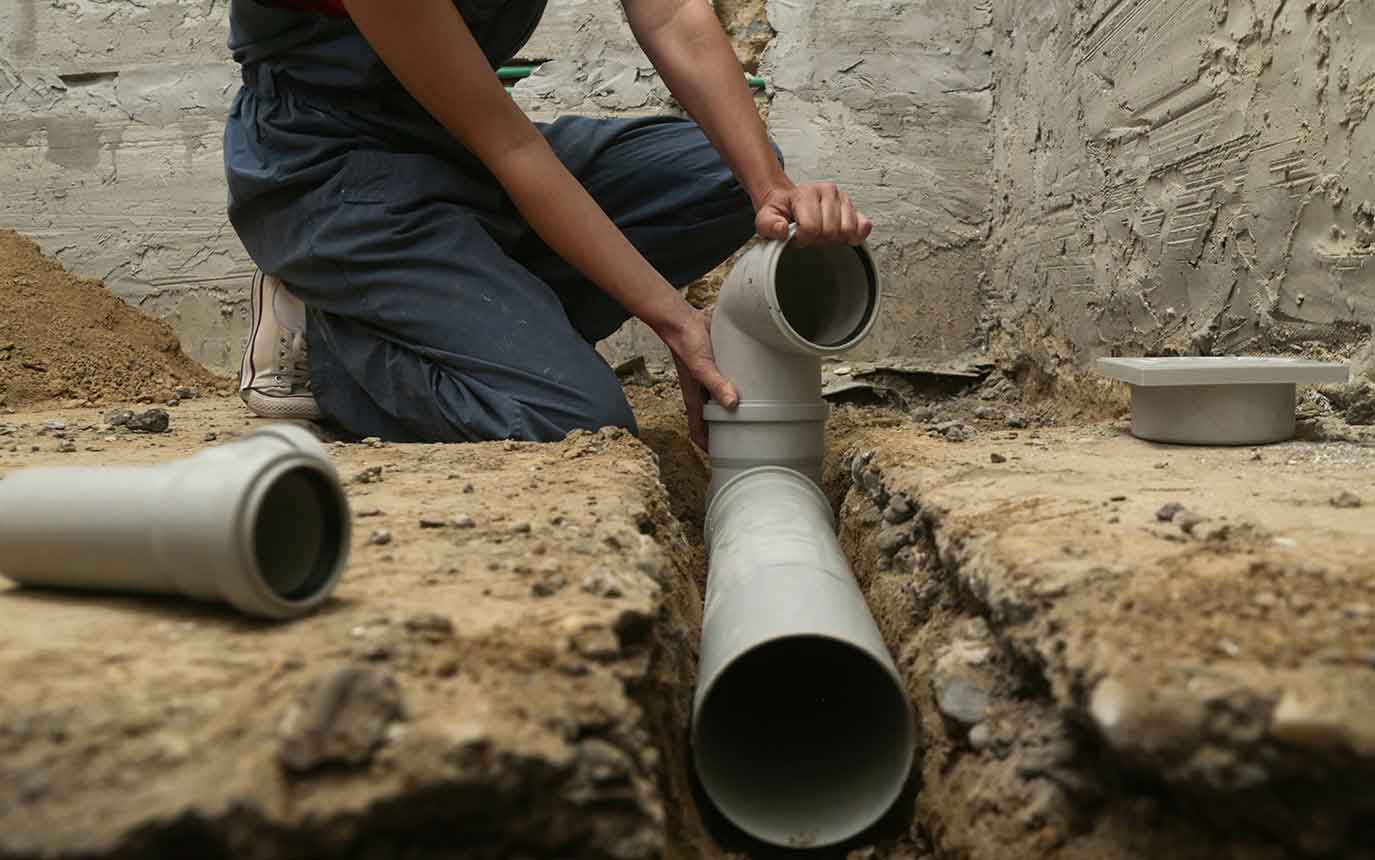 Mann verlegt ein unterirdisches Rohr