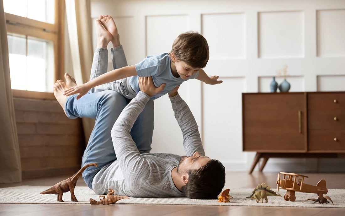 Vater spielt auf dem Boden mit seinem Sohn